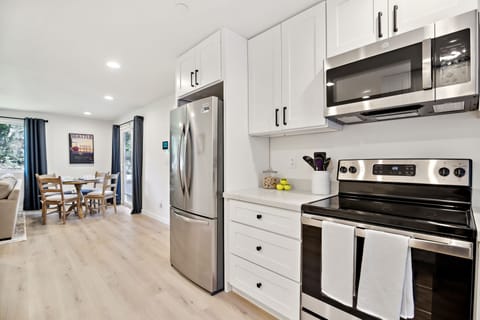 Open concept kitchen with new stainless steel appliances.