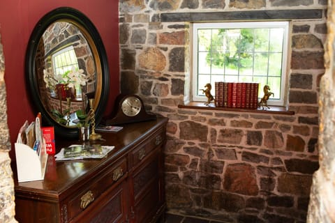 sideboard with round mirror and welcome pack with leaflets, books on window sill