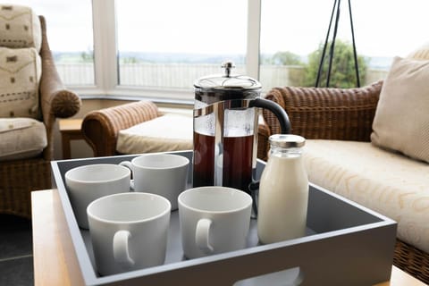 A tray in the conservatory with coffee, milk and mugs