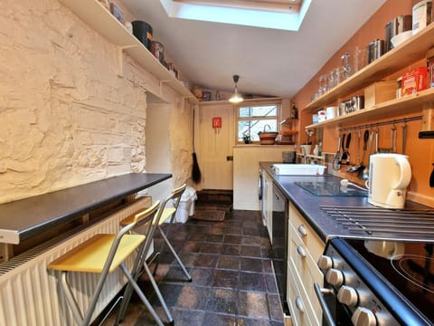 Kitchen with cooker, washing machine, sink, breakfast bar
