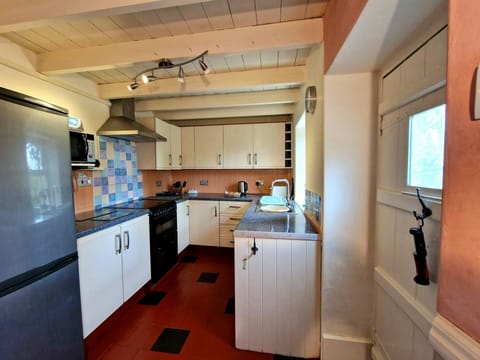 Kitchen with fridge/freezer, microwave and electric cooker