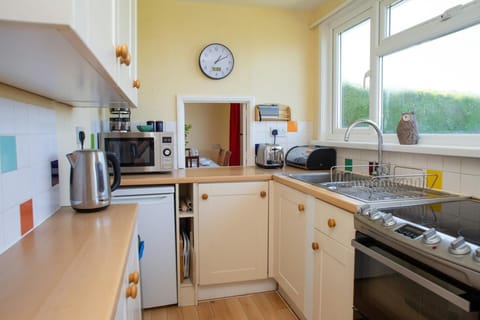 Kitchen with electric cooker, microwave and fridge