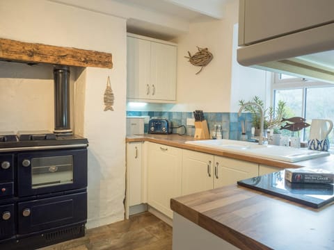 Kitchen with range cooker, wooden beam, kitchen units, sink and window