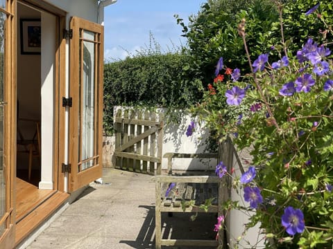 Patio area with bench and plants, french doors into house