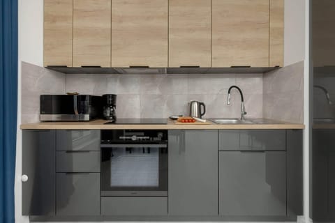 A modern kitchen featuring wooden cabinets, black appliances, and a sleek design.