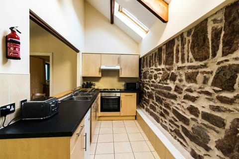 Toes Rock kitchen, oven and hob, toaster, sink, opening to dining area