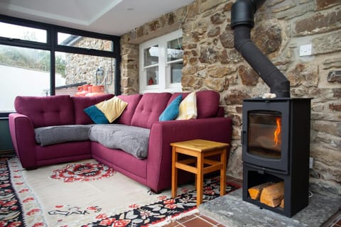 Conservatory with large corner sofa and woodburner