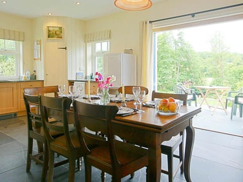 Dining area with table and chairs and doors open to the patio
