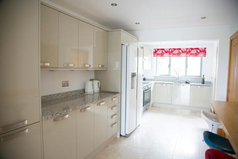 Kitchen with high and low level units, fridge freezer and breakfast bar