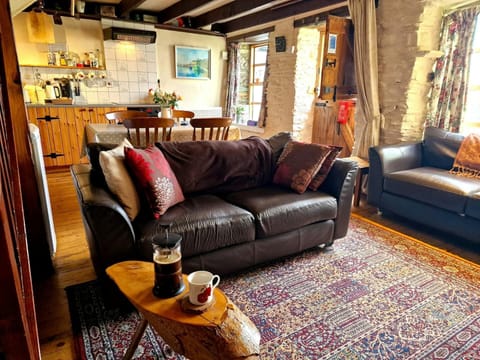 Living room, x2 2 seater leather sofas, dining table behind, wooden coffee table, large rug