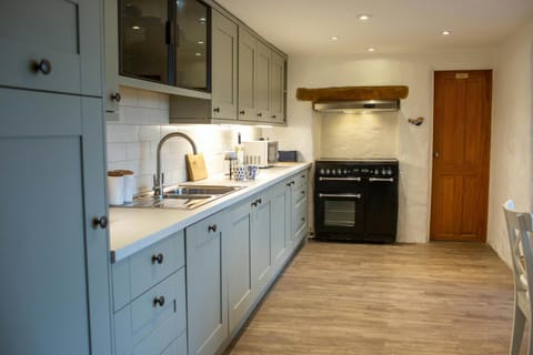 kitchen worktops built in across one wall, large cooker fitted into nook.