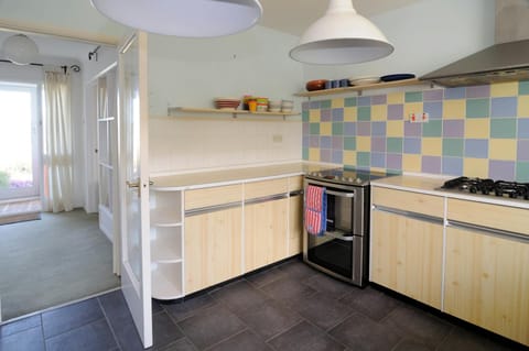 Kitchen with cooker, kitchen units and open shelf