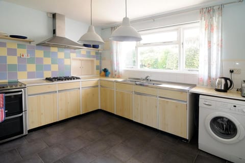 Kitchen with washing machine, oven and hob, sink and window