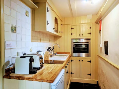 Kitchen with wooden units, hob, oven, toaster and kettle