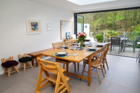 Dining table laid for dinner with a vase of flowers on the table