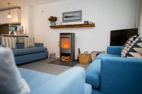 Living room with three sofas and wood burner