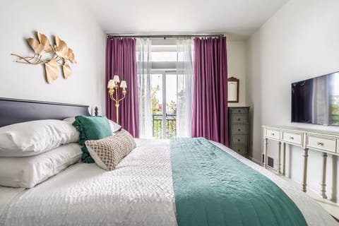 Bedroom looks out onto private balcony and features 43" TV