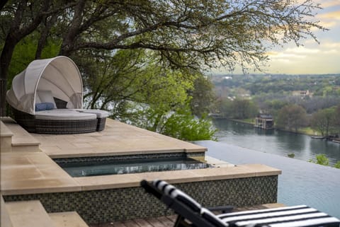 Outdoor daybed and spa overlooking the breathtaking view of the lake