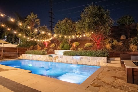 Pool with spa and baja shelf, automated, wireless controller, waterfall features and lights.