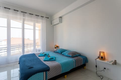 Bright bedroom with a comfortable bed, balcony offering clear views, air conditioning, and modern decor.