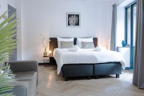 A well-lit bedroom at Bed and Coffee Central, featuring a comfortable bed, tasteful decor, and a serene ambiance, perfect for relaxing or enjoying a restful night’s sleep near Hotel Centrum Tilburg.