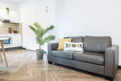 Relax in the cozy living space at Bed and Coffee Central, where a chic sofa and warm atmosphere offer the perfect setting for a restful, affordable stay.