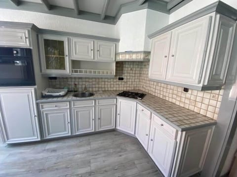 A spacious and bright kitchen with classic white cabinetry and modern appliances, offering a welcoming space for culinary creativity.