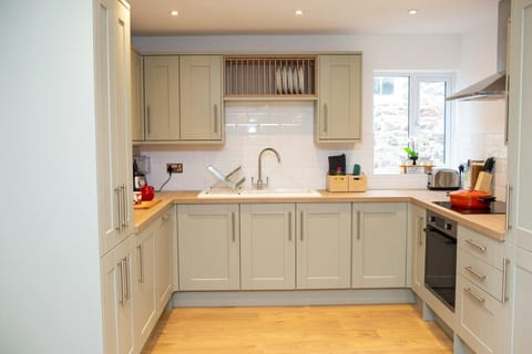 Kitchen with wall and base cupboards. Electric oven and hob