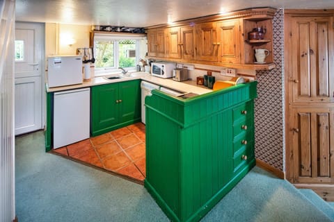 Green base cupboards and pine wall cupboards. Stable door and window looking out to the garden