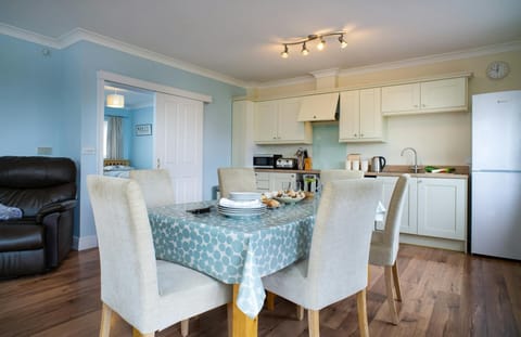 Dining area at Safe Haven with table and chairs and kitchen area