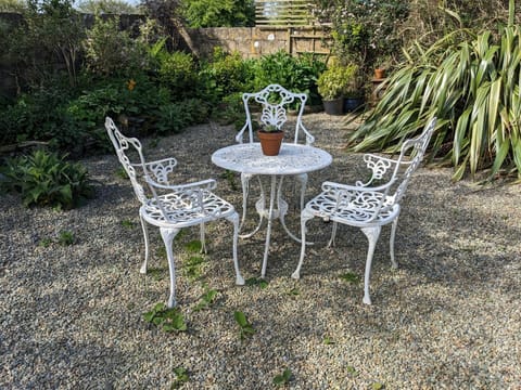 Outdoor seating area with wrought iron table and three chairs