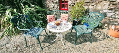 Sheltered walled garden with gravel, plants, table and chairs