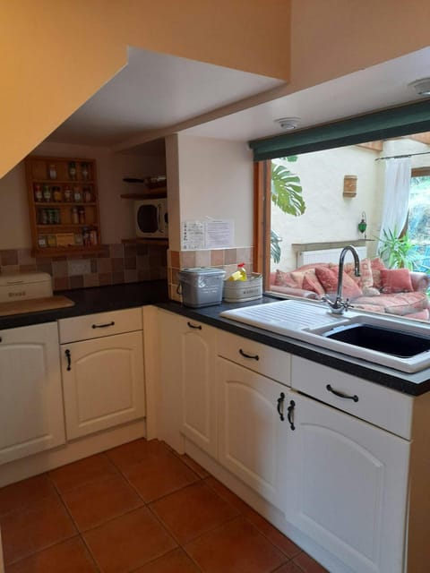 White base kitchen cupboards. Window looking into the conservatory