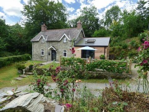 Front of Ty Cam with gardens, raised patio with picnic table