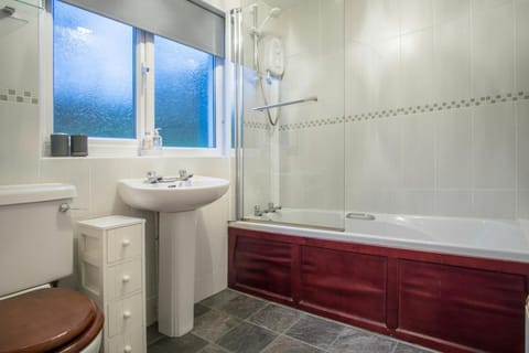 Bath with a shower over, WC, cupbard and wash hand basin