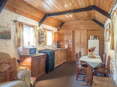Dining area and kitchen, wood beamed ceiling, two windows