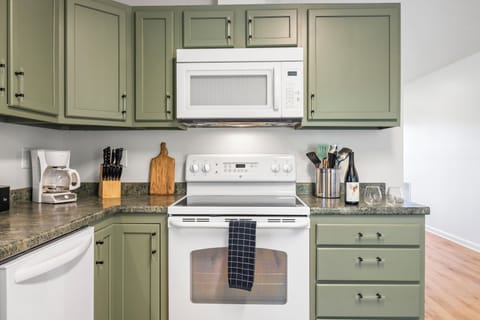 Kitchen with modern stove, microwave, and oven.