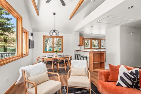 The open-concept living/dining room with large windows framing your riverside oasis