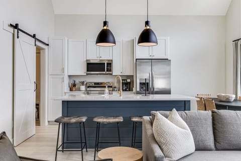 Interior-designed and fully-stocked modern kitchen with stainless steel appliances, granite countertops, and bar seating for 4 people