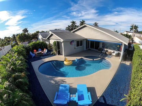 Tropical backyard escape with pool, palm trees, cornhole game and BBQ Grill.