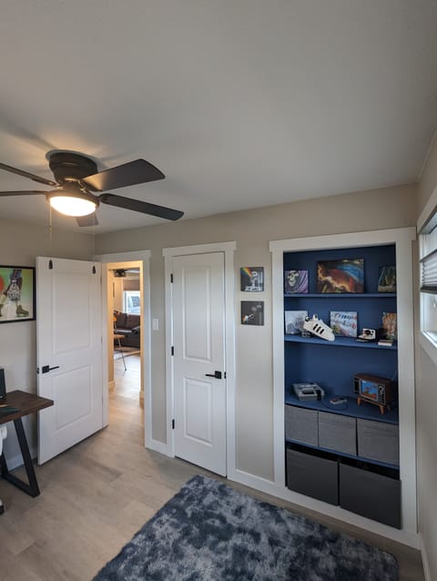Full closet with display cabinets, original artwork, black-out blinds & storage.