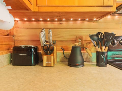 Toaster, knife set, goose-neck kettle, and cooking utensils.