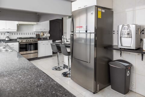 Modern kitchen with full-size refrigerator and all the essentials for cooking at home.