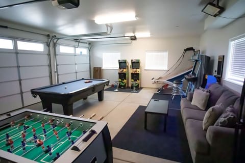 Game room with pool table, basketball, foosball, dart board, arcade game with 4,000+ games, smart TV, beer pong & couch.