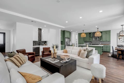 Full bar with sink and wine cooler next to the kitchen