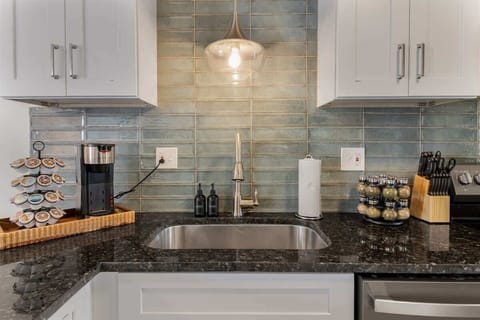 Stylish kitchen corner with an eye-catching turquoise tile backsplash, where functionality meets modern design aesthetics.