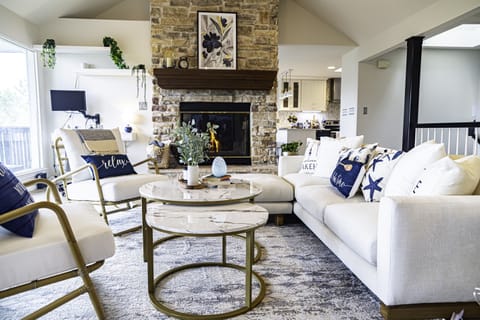 At the heart of the room, a stone fireplace stands as a focal point, its crackling flames casting a warm, inviting glow on chilly evenings. 