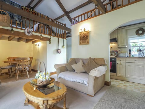 Nyth y Wennol sitting room leading to dining area with round table and four chairs