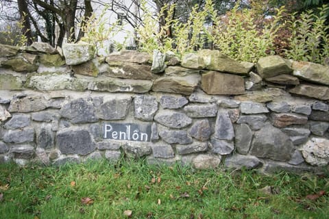 Slate sign saying Penlon embedded in stone farm wall