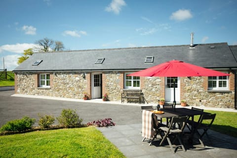 Beudy Nel with tarmac drive, paved patio with table, chairs, umbrella and lawn